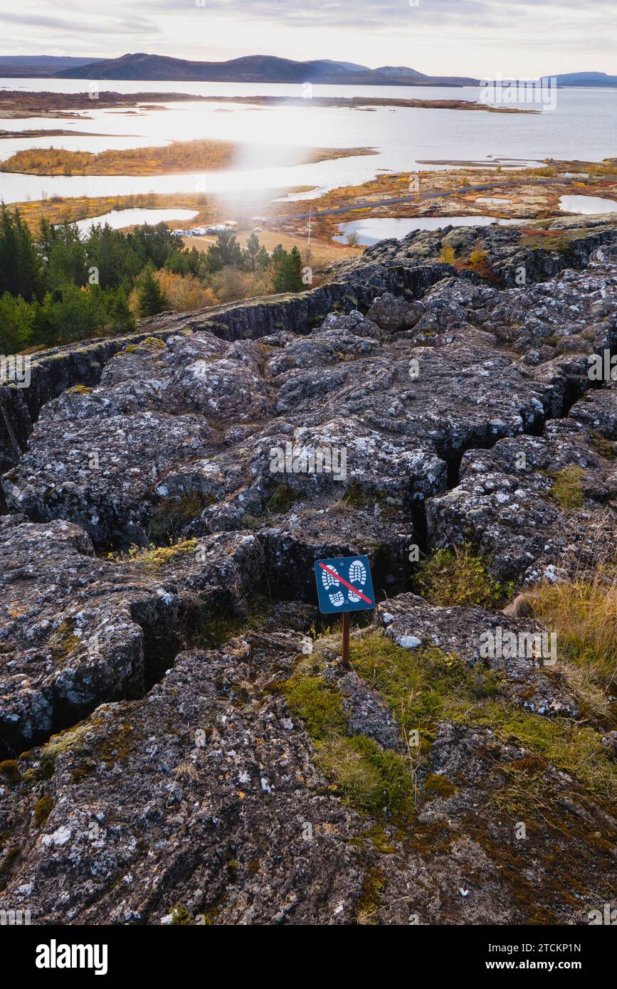 Islanda, Circolo d'Oro, Parco Nazionale di Thingvellir nei colori autunnali. Il Rift medio-Atlantico tra le placche tettoniche nordamericane ed eurasiatiche. Il lago Thingvallavtr, il più grande lago d'Islanda, situato sulla dorsale di Reykjares. Fessure in primo piano. Foto Stock