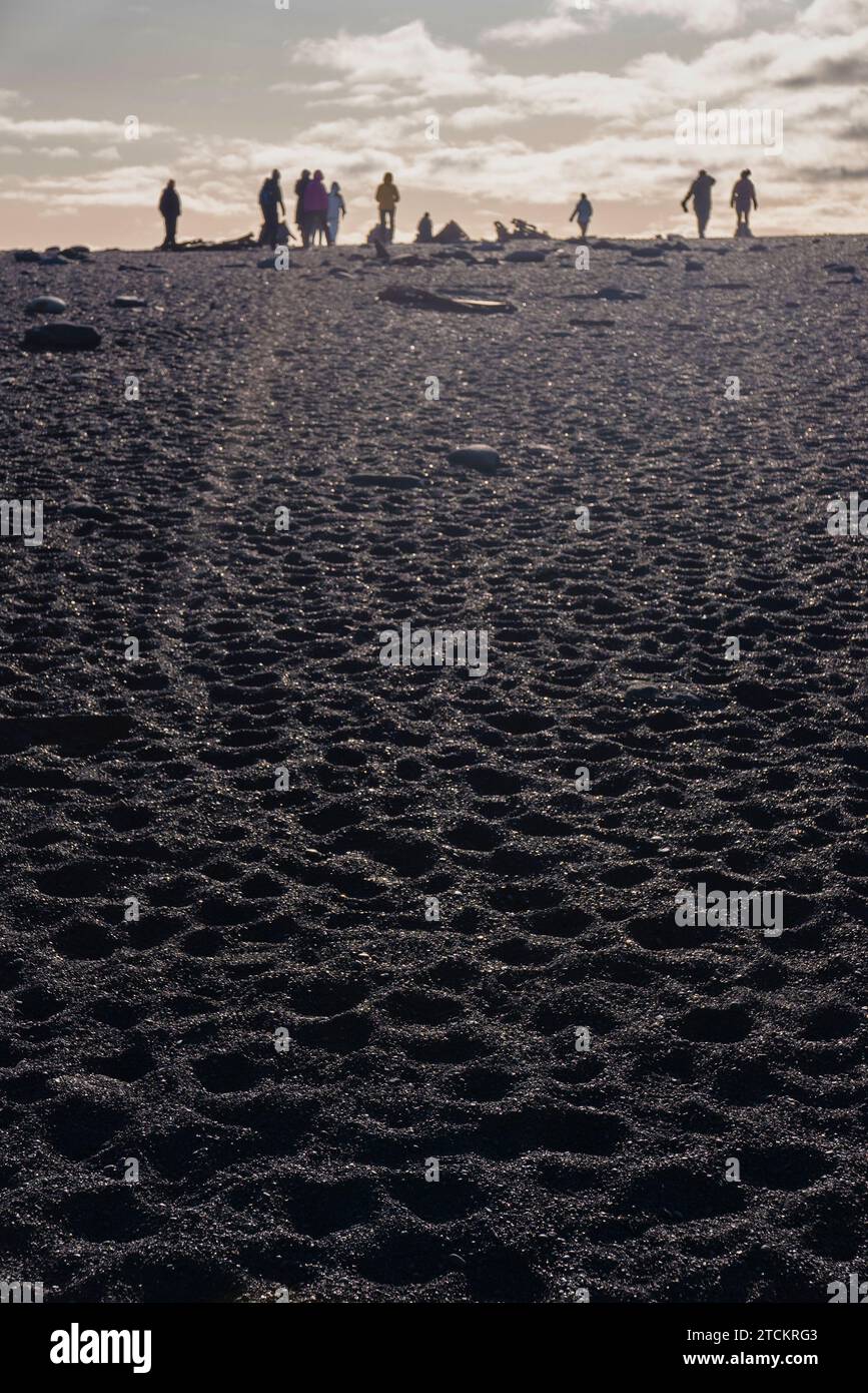Islanda, Parco nazionale della penisola di Snæfellsnes, spiaggia di sabbia nera di Djúpalónssandur. I turisti che visitano la città si stagliano sullo skyline. Foto Stock