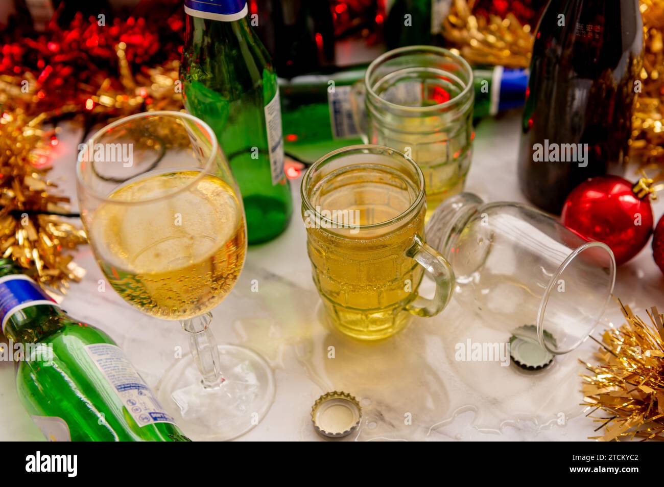 Un concetto di festa di Natale con bicchieri e bottiglie di bevande alcoliche e decorazioni su un tavolo. Foto Stock