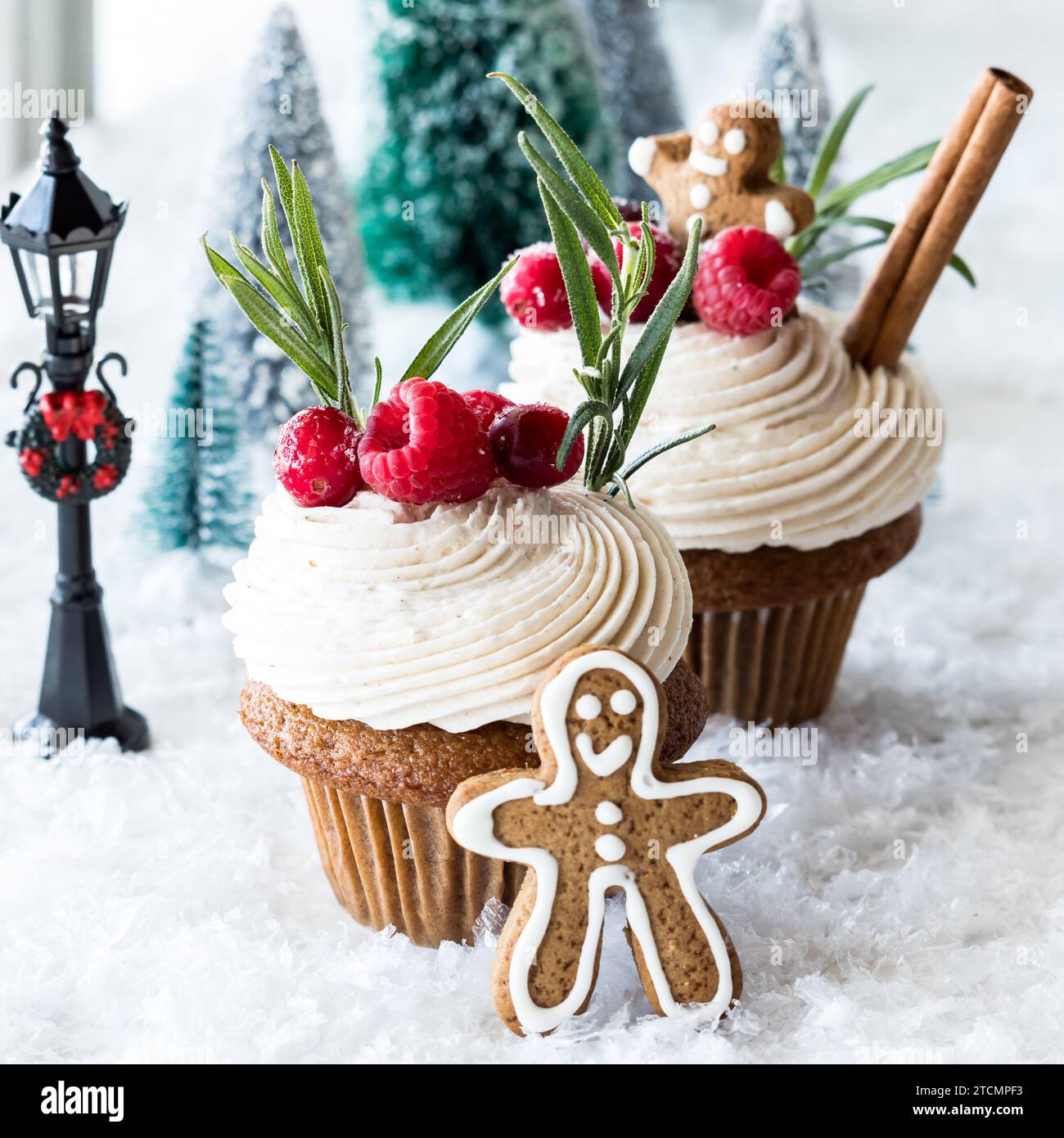 Cupcake di pan di zenzero con glassa alla crema di burro, conditi con decorazioni festive. Foto Stock