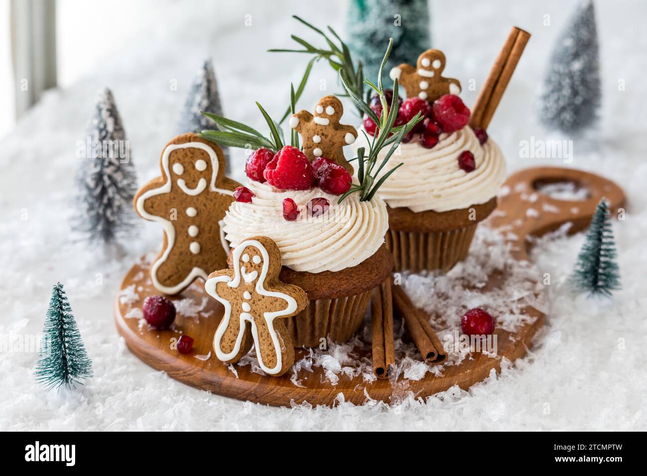 Cupcake di pan di zenzero con glassa alla crema e condimenti per le feste. Foto Stock