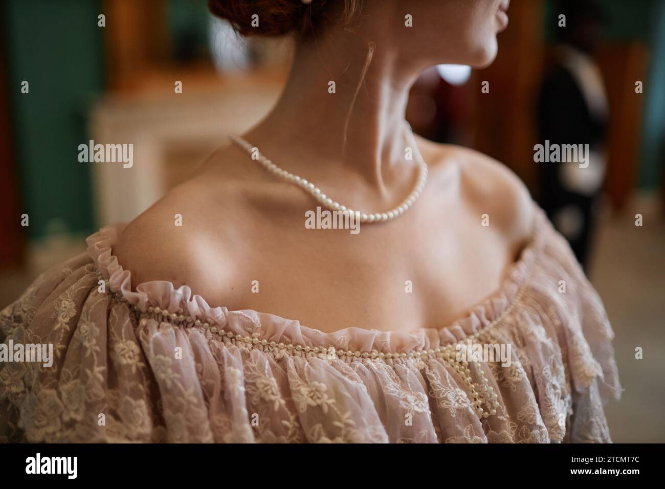 Primo piano di una giovane donna che indossa un abito da ballo con scollatura elegante con perle e spazio per la copia Foto Stock