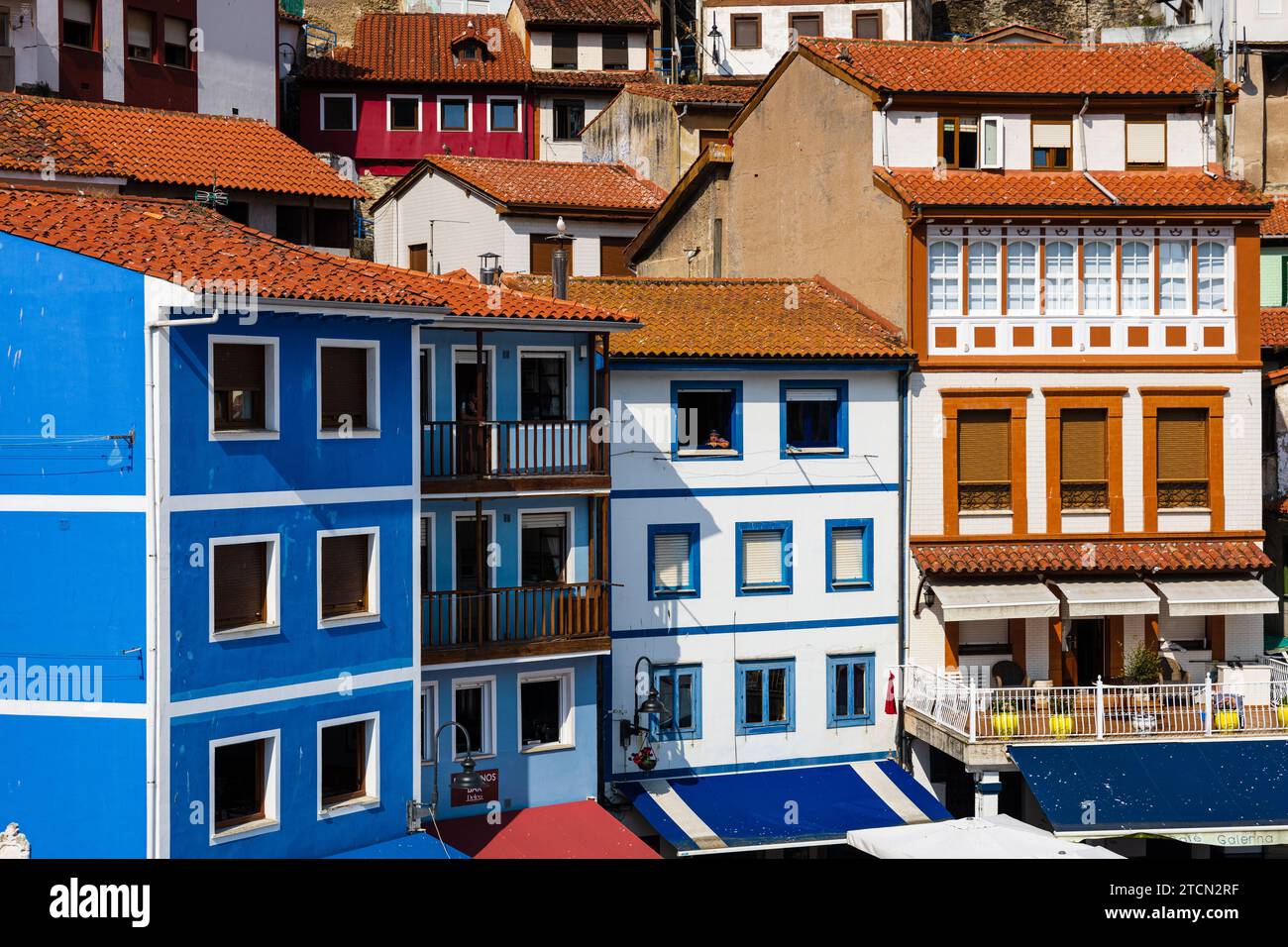 Diverse case colorate tradizionali con tetti di tegole rosse in primo piano nel centro. Cudillero, Asturie, Spagna. Foto Stock