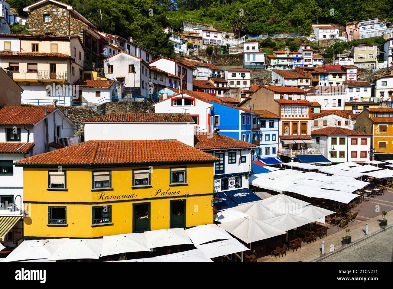 La piazza principale e la vista di una piccola cittadina di pescatori, le tradizionali case bianche e colorate con tetti di tegole rosse. Cudillero, Asturie, Spagna. Foto Stock