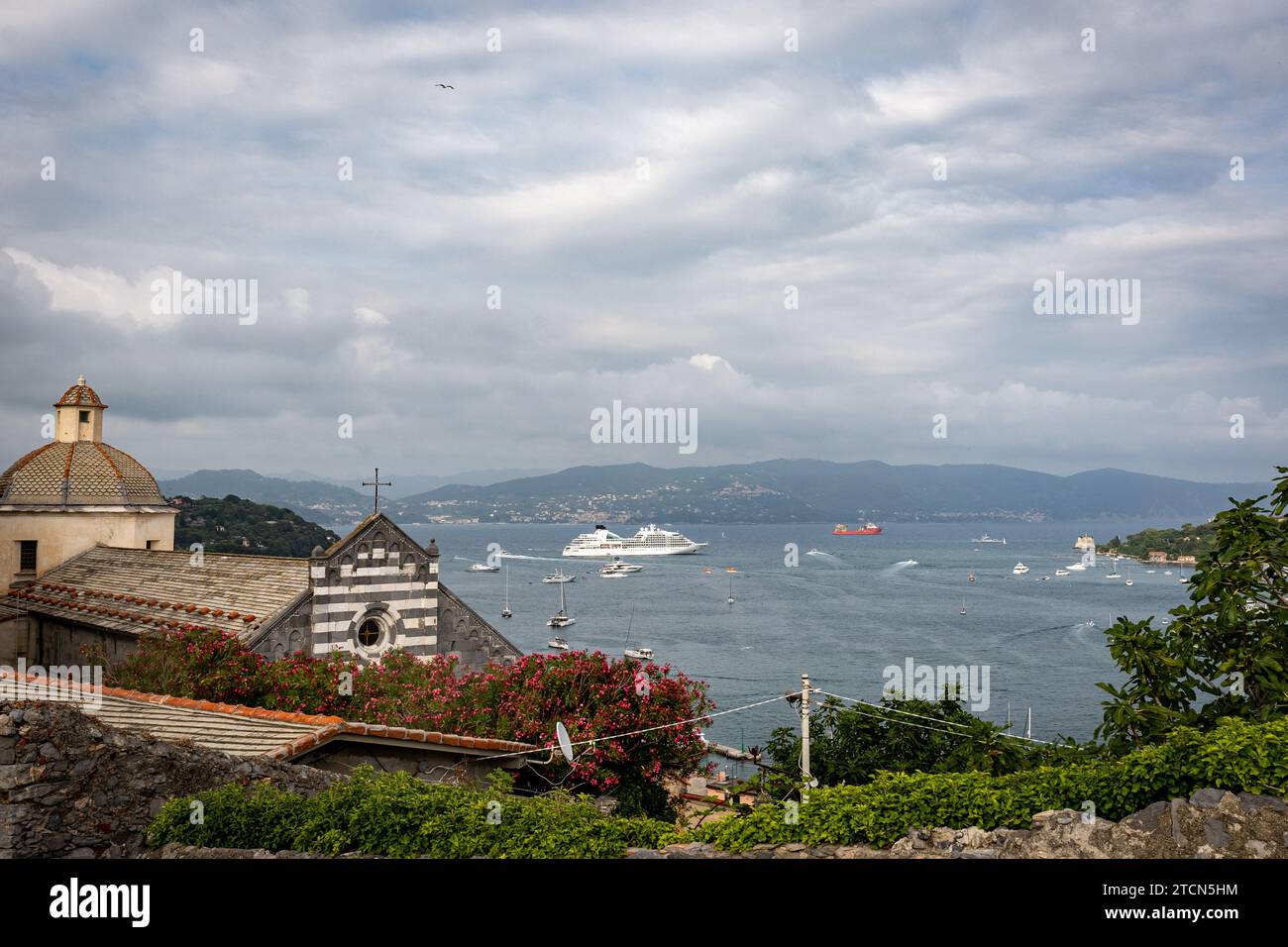 Vista della chiesa e del mare con le barche e la nave nella città di Portovenere, Italia Foto Stock