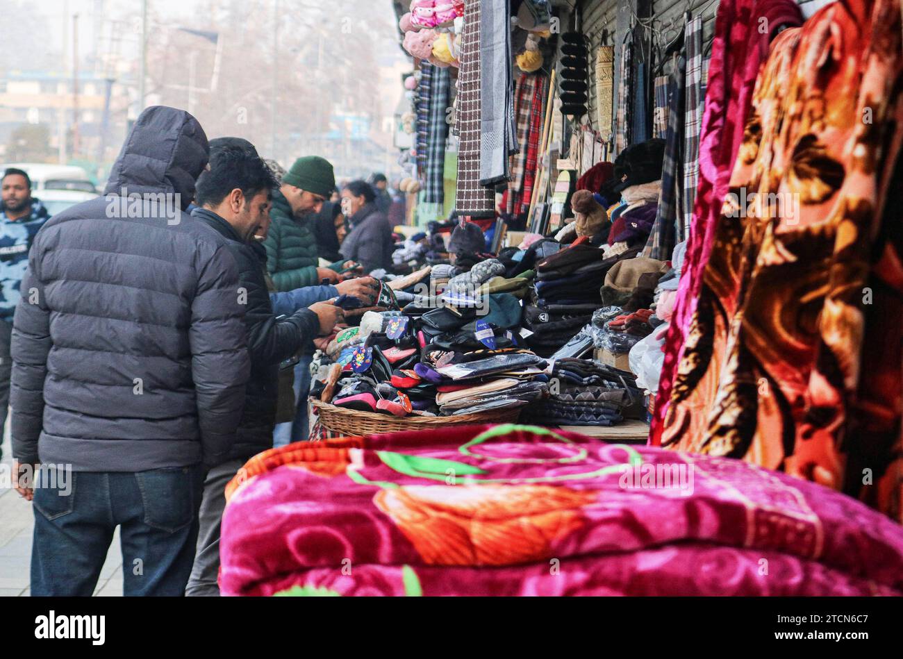 Vendita di abbigliamento invernale durante la stagione invernale 13 dicembre 2023, Srinagar Kashmir, India: La gente acquista cappellini invernali e altri articoli presso un mercato a Srinagar. Con l'arrivo dell'inverno, i Kashmiris ordinari iniziano a prepararsi per il tempo duro, acquistando maglioni, giacche e altri vestiti caldi. Srinagar Kashmir India Copyright: XFirdousxNazirxxEyepixxGroupx Foto Stock