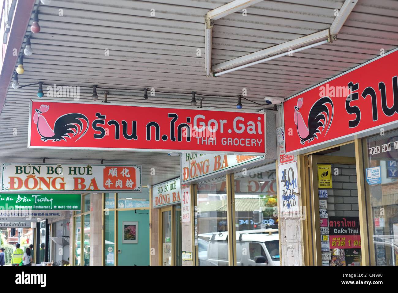 I cartelli per la drogheria tailandese e il ristorante vietnamita si trovano a mano dalla tenda per strada su Park Rd Cabramatta, comunità asiatica multiculturale, Sydney occidentale Foto Stock