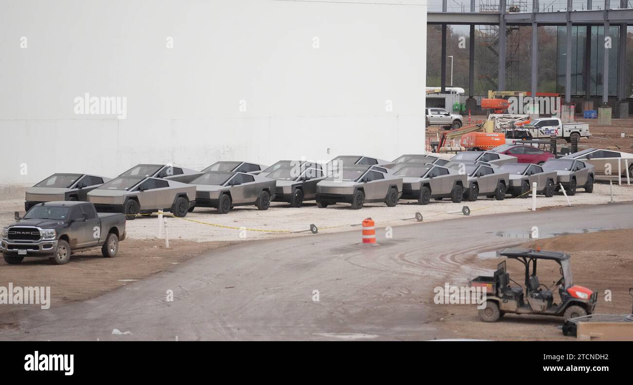 Austin, Texas, Stati Uniti. 13 dicembre 2023. I nuovi Tesla Cybertruck sono parcheggiati fuori dall'enorme fabbrica Tesla nel sud-est di Austin mentre i lavoratori effettuano controlli sulle attrezzature e li allontanano il 13 dicembre 2023, due settimane dopo aver consegnato i primi modelli agli acquirenti VIP in una cerimonia privata. È in corso una massiccia espansione presso lo stabilimento Tesla in Texas, con la costruzione di diversi nuovi edifici. (Immagine di credito: © Bob Daemmrich/ZUMA Press Wire) SOLO USO EDITORIALE! Non per USO commerciale! Foto Stock