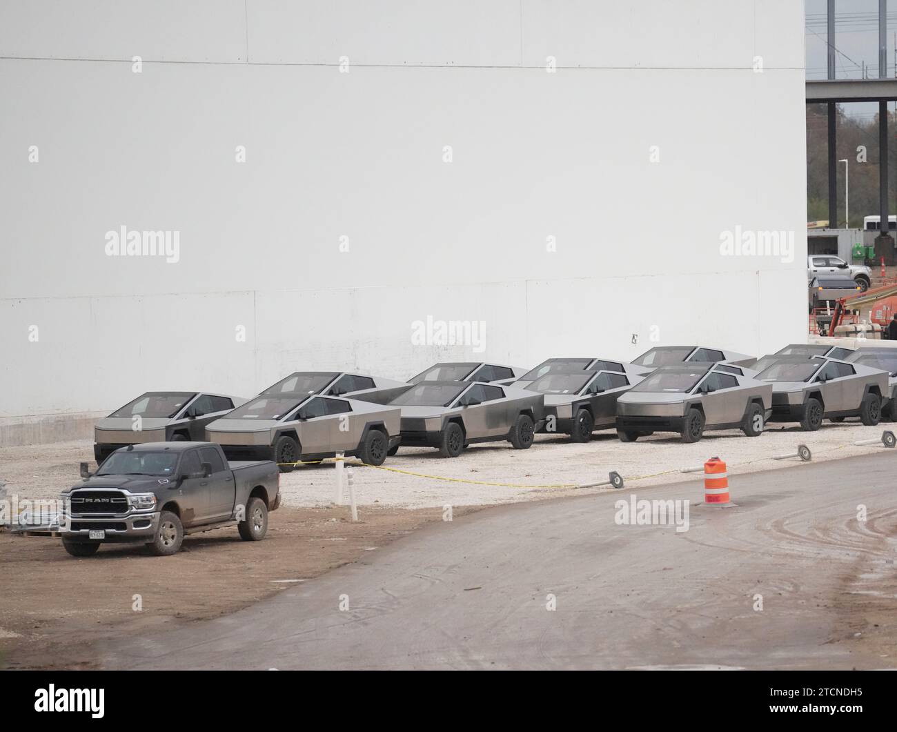 Austin, Texas, Stati Uniti. 13 dicembre 2023. I nuovi Tesla Cybertruck sono parcheggiati fuori dall'enorme fabbrica Tesla nel sud-est di Austin mentre i lavoratori effettuano controlli sulle attrezzature e li allontanano il 13 dicembre 2023, due settimane dopo aver consegnato i primi modelli agli acquirenti VIP in una cerimonia privata. È in corso una massiccia espansione presso lo stabilimento Tesla in Texas, con la costruzione di diversi nuovi edifici. (Immagine di credito: © Bob Daemmrich/ZUMA Press Wire) SOLO USO EDITORIALE! Non per USO commerciale! Foto Stock