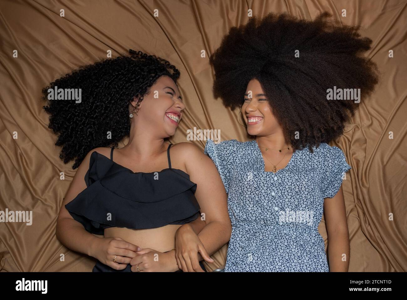 Ritratto semi-chiuso di due donne sdraiate che si guardano. Solido concetto di amicizia. Foto Stock