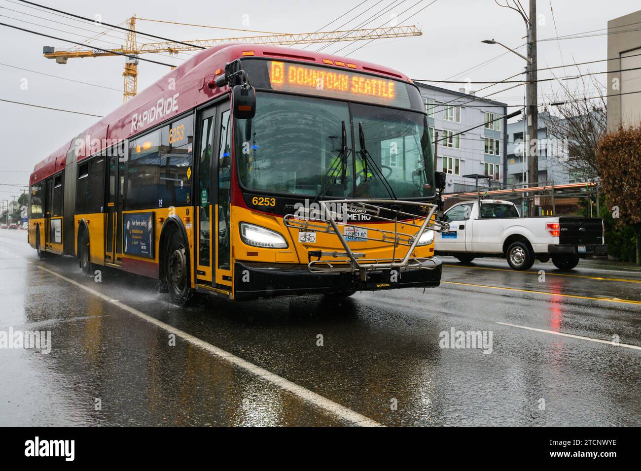 Seattle, WA, USA - 12 gennaio 2023; autobus King County Metro RapidRide per il centro di Seattle sulla bagnata strada urbana di Seattle sotto la pioggia Foto Stock