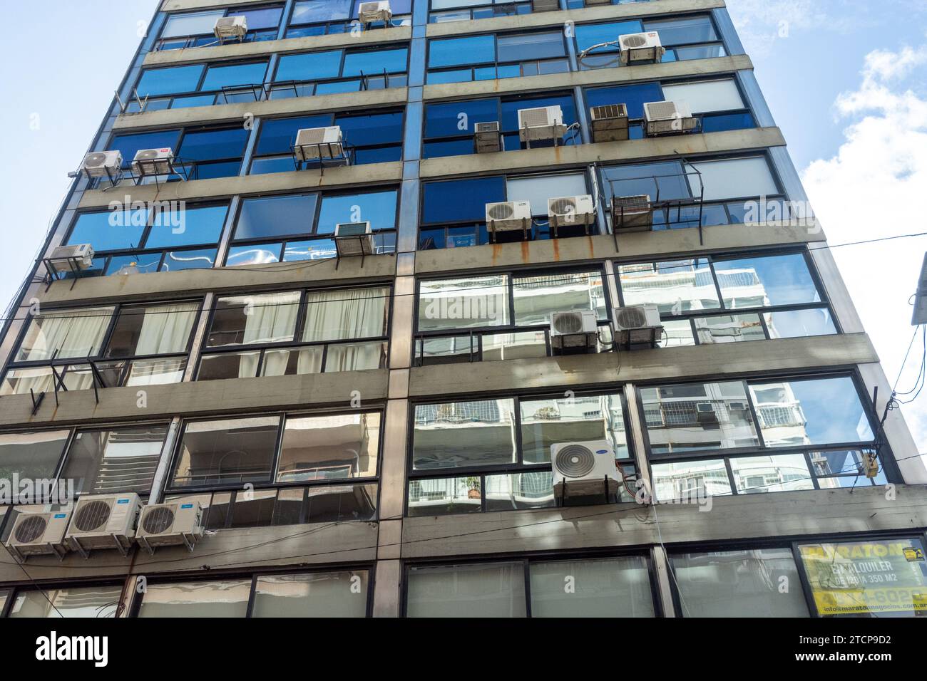 alto edificio cittadino con una facciata in vetro, con molti condizionatori d'aria che fuoriescono dalle finestre. buenos aires. argentina. sud america Foto Stock