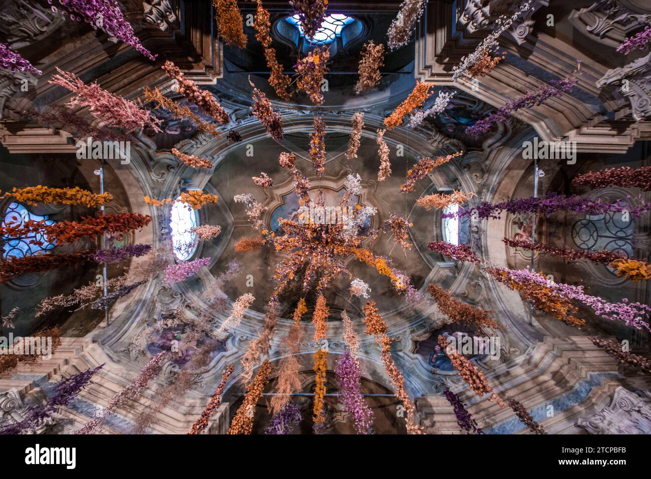 Veduta eterea del Florilegium di Rebecca Louise Law: Migliaia di fioriture sospese sotto la cupola barocca di San Tiburzio, Parma. Arte floreale coinvolgente. Foto Stock