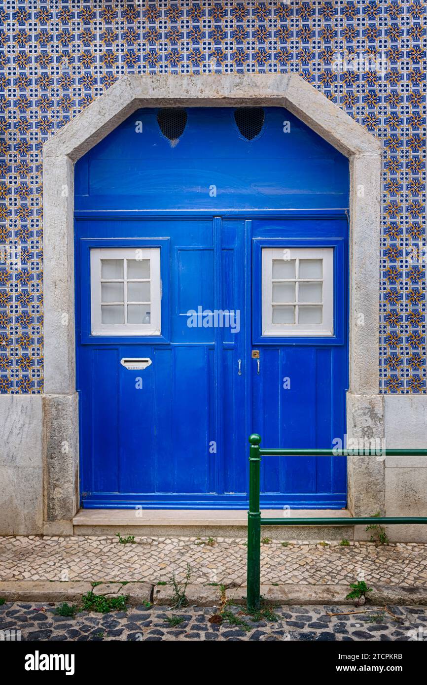 Porta blu con una casa con facciata piastrellata, Lisbona, Portogallo Foto Stock