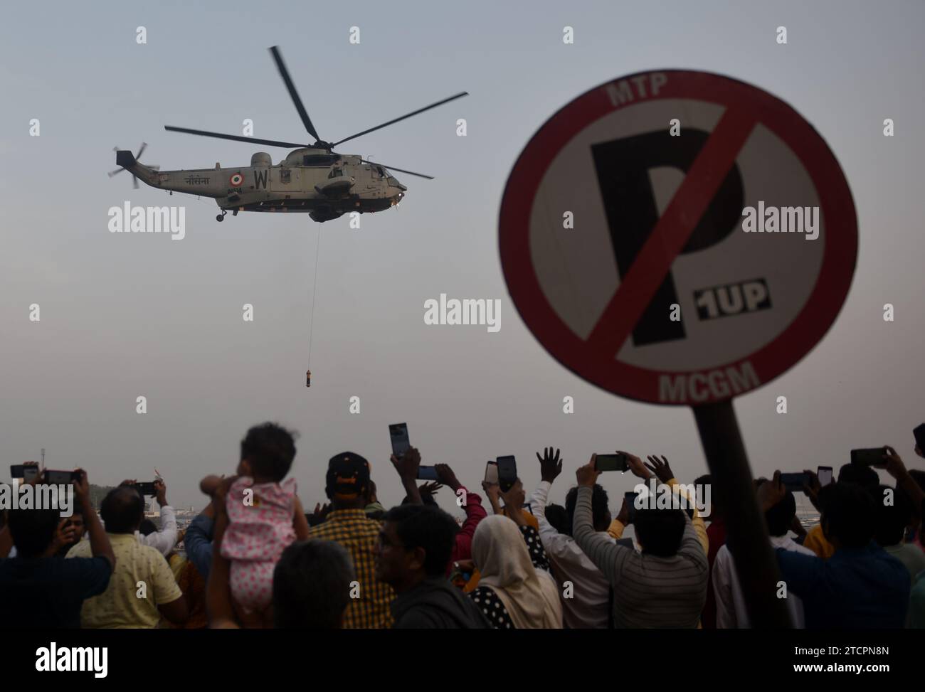 Le persone si stanno riunendo per vedere l'elicottero esposto dai commando marini della Marina indiana mentre dimostrano le loro abilità, parte della celebrazione del Navy Day a Mumbai, in India, il 13 dicembre 2023. (Foto di Indranil Aditya/NurPhoto) credito: NurPhoto SRL/Alamy Live News Foto Stock