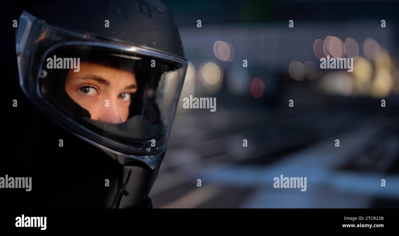 Giovane bella motociclista donna in un casco da moto, sicurezza stradale, equipaggiamento da moto Foto Stock
