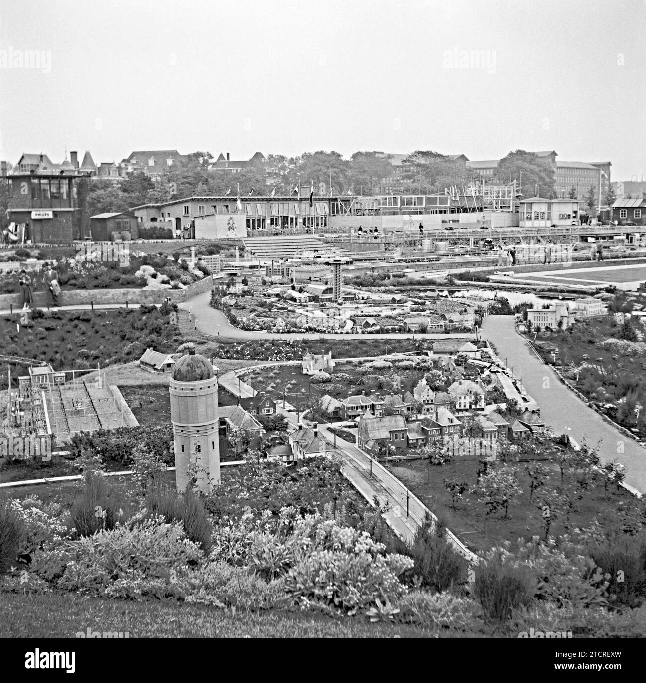 Madurodam, l'Aia, Paesi Bassi, fotografato nel 1955 – questo punto di vista mostra che i lavori di costruzione erano ancora in corso presso le strutture per i visitatori (sul retro). Madurodam è un parco a tema in miniatura, un villaggio modello e un'attrazione turistica nel distretto di Scheveningen dell'Aia. È sede di una gamma di repliche di modelli in scala 1:25 di famosi monumenti e stili di vita olandesi, città storiche, industria e sviluppi. Il parco è stato aperto nel 1952 e decine di milioni di visitatori hanno visitato l'attrazione con i profitti del parco diretti a varie organizzazioni benefiche nei Paesi Bassi. Foto Stock