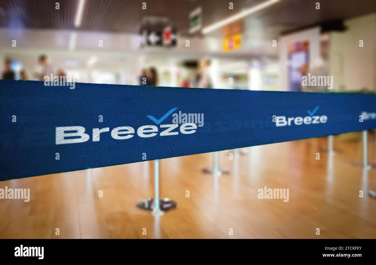 Charleston, US, Nov. 28 2023: Attenzione selettiva su un nastro blu a marchio Breeze Airways utilizzato come separatore di code in un terminal aeroportuale, con bl Foto Stock