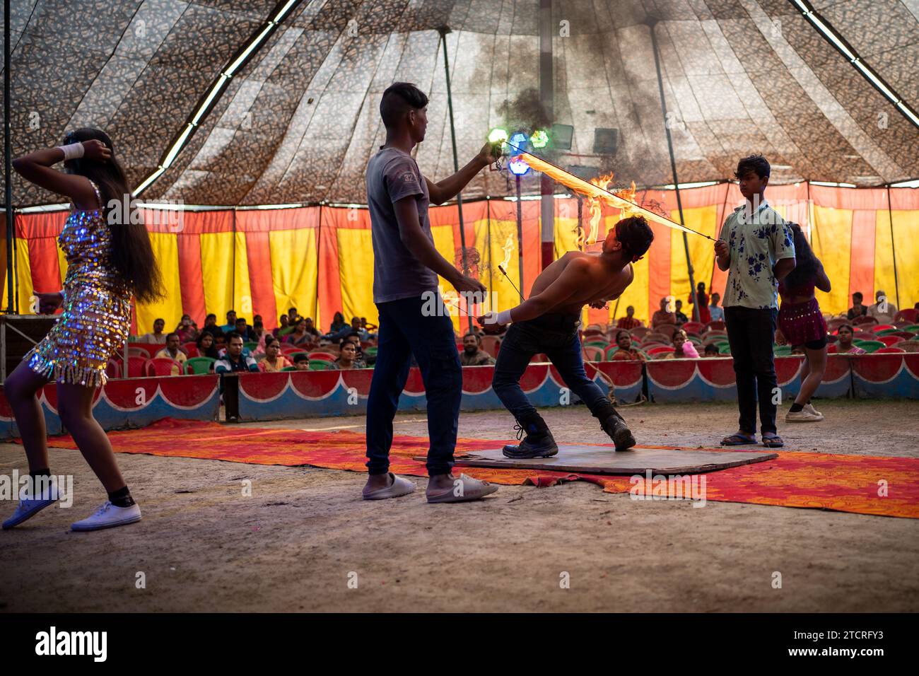 Kolkata, India. 14 dicembre 2023. Un artista mostra le sue acrobazie di fuoco a una tenda da circo come si vede a Calcutta. L'inverno e l'infanzia significavano un periodo in cui c'era un'attrazione e un amore distinti per il circo. Ma ora i tempi sono cambiati, quindi anche la domanda è diminuita, soprattutto dopo che lo spettacolo di qualsiasi tipo di animale nel circo si è fermato, i proprietari delle squadre del circo sono più sconvolti. Ora il gioco è mostrato solo con jolly o persone. E di conseguenza il reddito è diminuito. Ora anche i più piccoli hanno perso interesse per il circo. Credito: SOPA Images Limited/Alamy Live News Foto Stock
