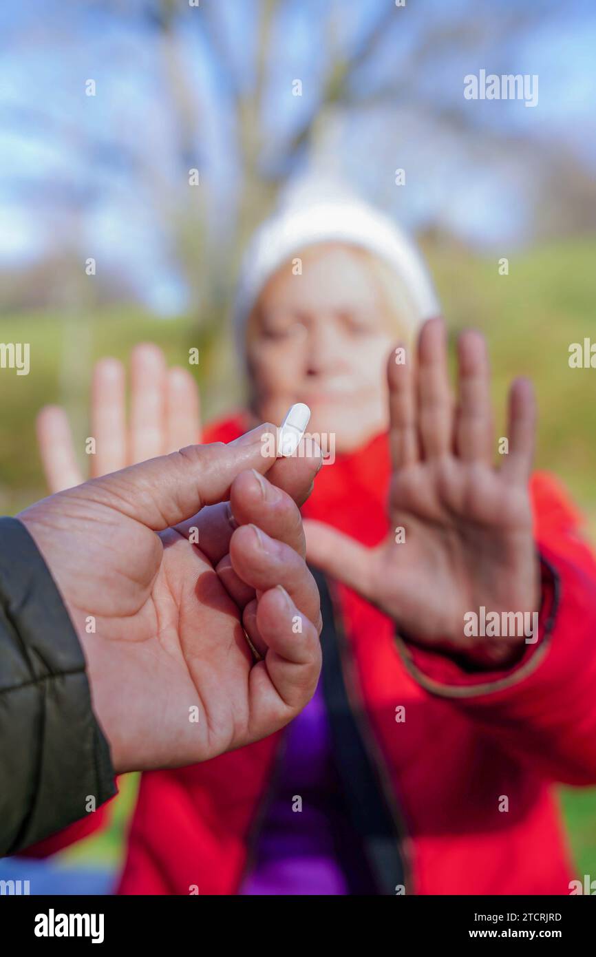 Donna che rifiuta una pillola con la mano. Campagna di sensibilizzazione contro la droga e prevenzione dell'abuso di droga. Giornata mondiale della droga Foto Stock