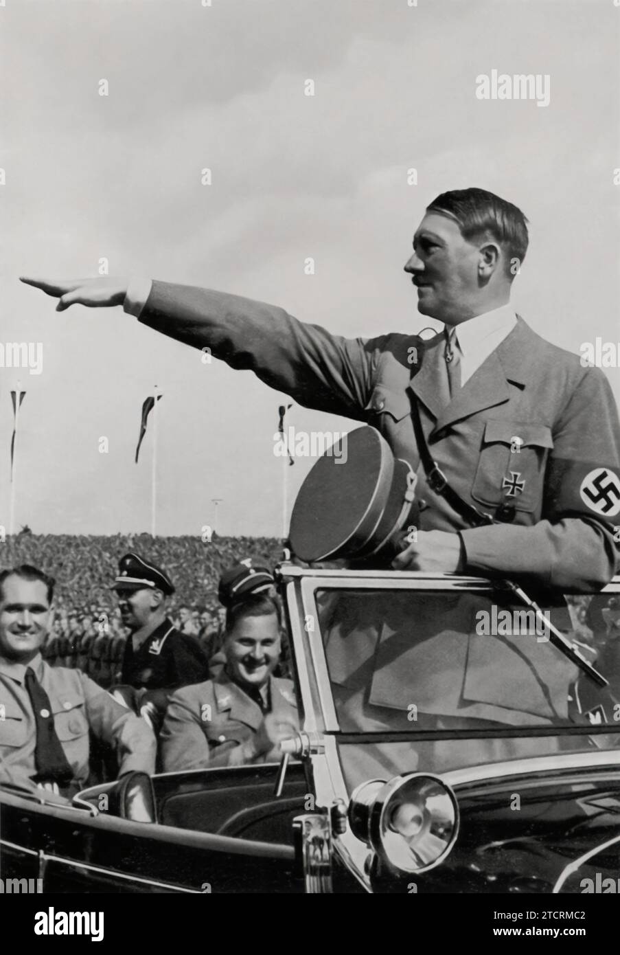Adolf Hitler è visto interagire con i giovani al Reichsparteitag del 1935. Questa immagine evidenzia l'enfasi del regime sul coinvolgimento dei giovani e l'indottrinamento, un aspetto chiave della propaganda nazista. La presenza di Hitler tra i giovani sostenitori in un evento così significativo sottolinea l'importanza che il regime ha posto nel coltivare la lealtà e il senso di appartenenza alla generazione più giovane, parte integrante della sua strategia a lungo termine. Foto Stock