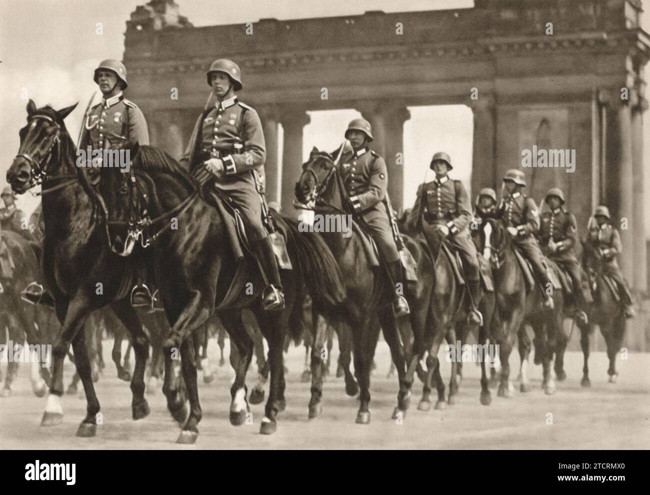 I soldati tedeschi sfilano a cavallo davanti al Fuhrer (Adolf Hitler), una dimostrazione di disciplina militare e abilità della cavalleria. Questo evento mette in mostra l'efficacia della loro formazione e il significato storico delle truppe a cavallo nella tradizione militare e nella cerimonia. Foto Stock