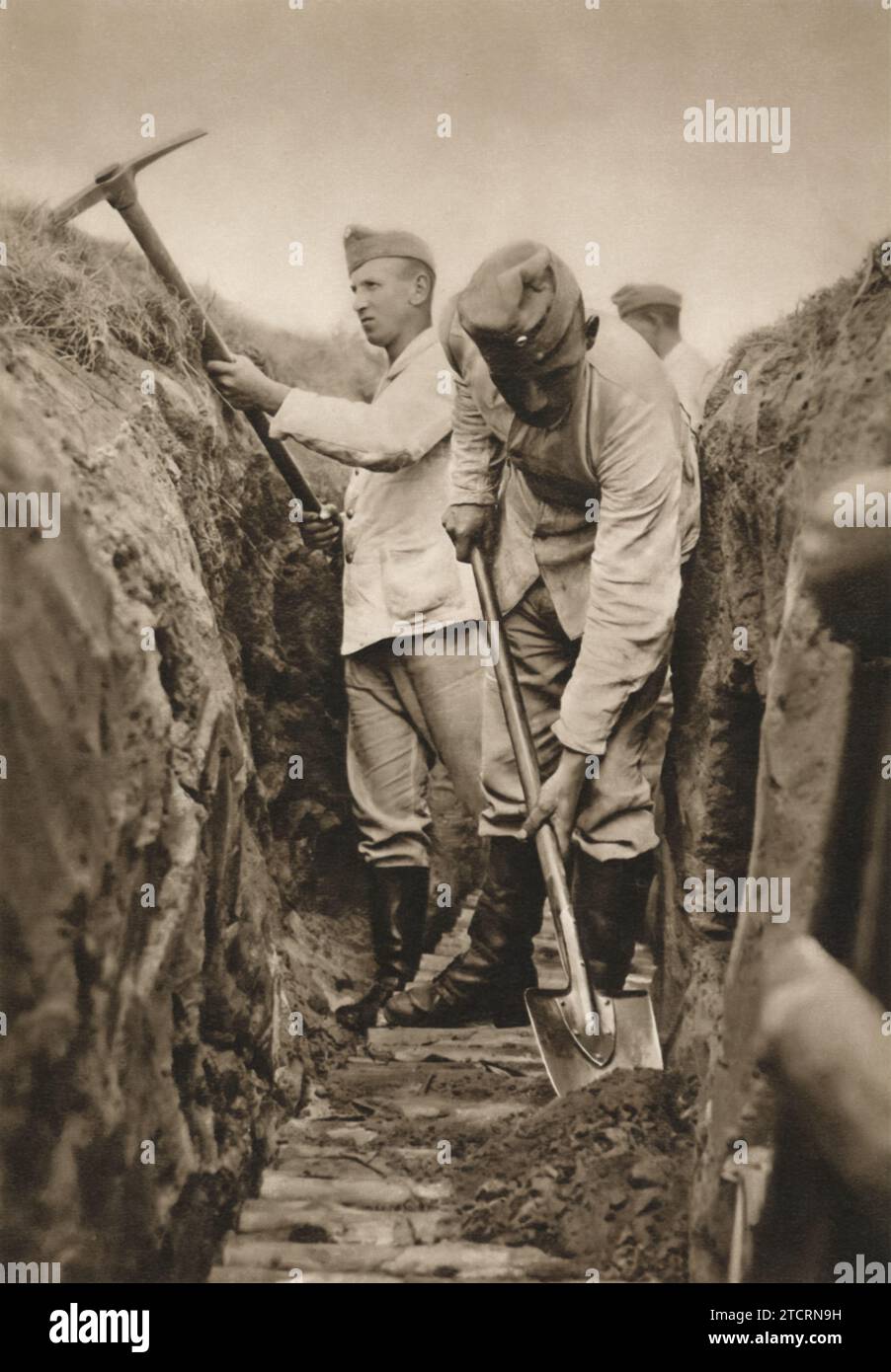I soldati tedeschi dotati di picchetti e pale sono impegnati a costruire una trincea, un aspetto fondamentale della fortificazione del campo di battaglia. Questa scena cattura lo sforzo faticoso e meticoloso coinvolto nella costruzione di trincee, un compito fondamentale per la creazione di posizioni difensive nelle operazioni militari. La trincea non solo fornisce protezione, ma anche un vantaggio strategico in varie situazioni di combattimento. Foto Stock