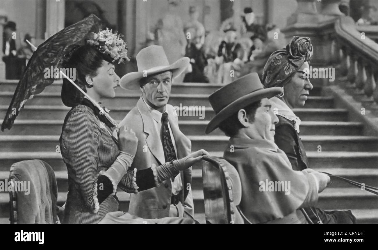Ingrid Bergman, Gary Cooper, Jerry Austin e Flora Robson sono catturati in una scena memorabile da "Saratoga Trunk" (1946), dove vengono visti viaggiare su una carrozza trainata da cavalli. Il film, ambientato alla fine degli anni '1800, riporta in vita una storia di amore e ambizione sullo sfondo delle aspettative della società. Foto Stock