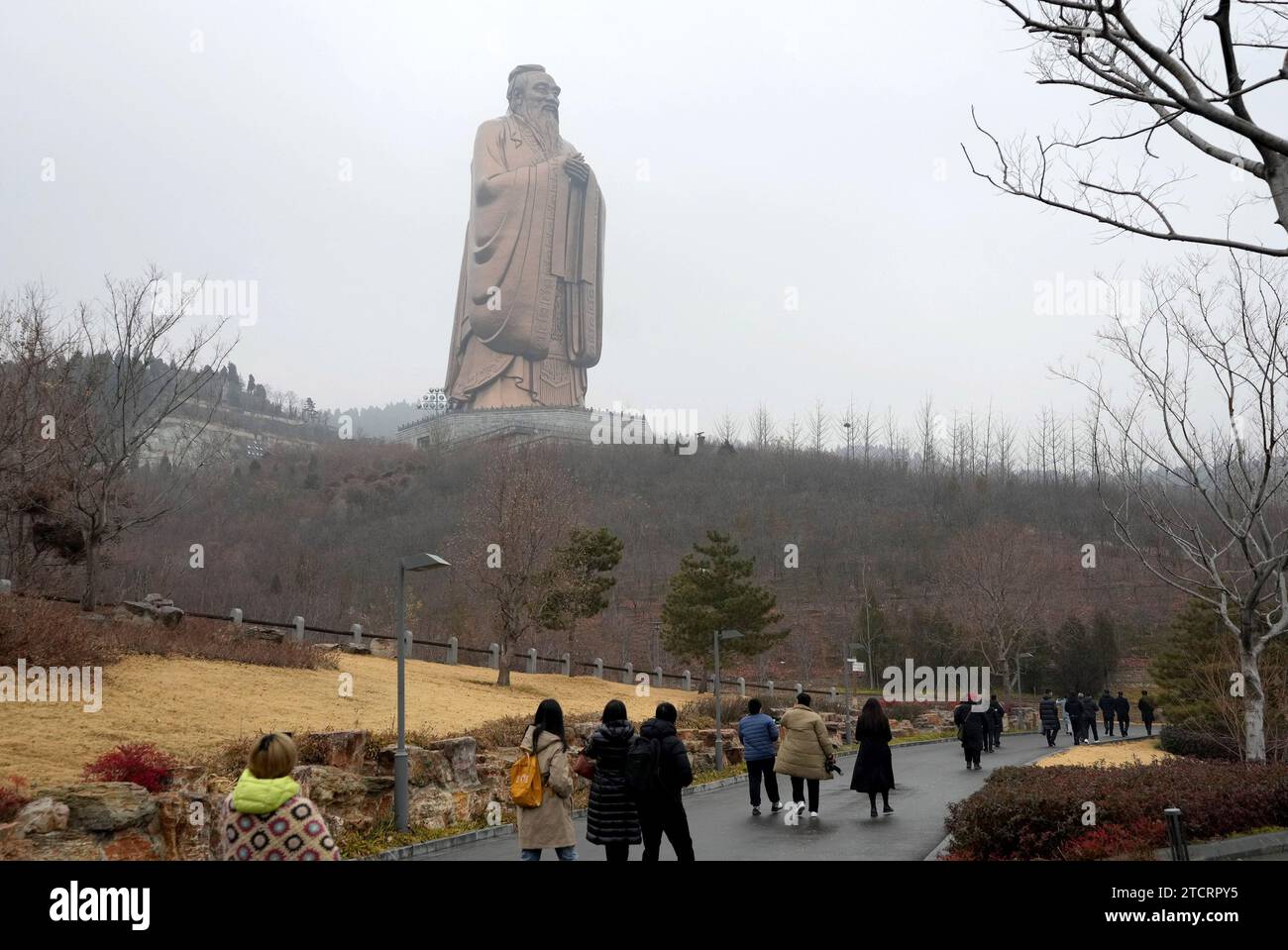 (231214) -- QUFU, 14 dicembre 2023 (Xinhua) -- la gente cammina davanti alla statua di Confucio nel punto panoramico di Nishan Sacredland nella città di Qufu nella provincia dello Shandong della Cina orientale, 13 dicembre 2023. Il punto panoramico di Nishan Sacredland, situato nella città di Qufu, ha iniziato la sua costruzione nel 2012 e ha aperto la sua area centrale al pubblico nel 2018. Il punto panoramico, una destinazione per esplorare il confucianesimo, ha ricevuto quasi 2 milioni di turisti quest'anno. (Xinhua/Wang Yuguo) Foto Stock