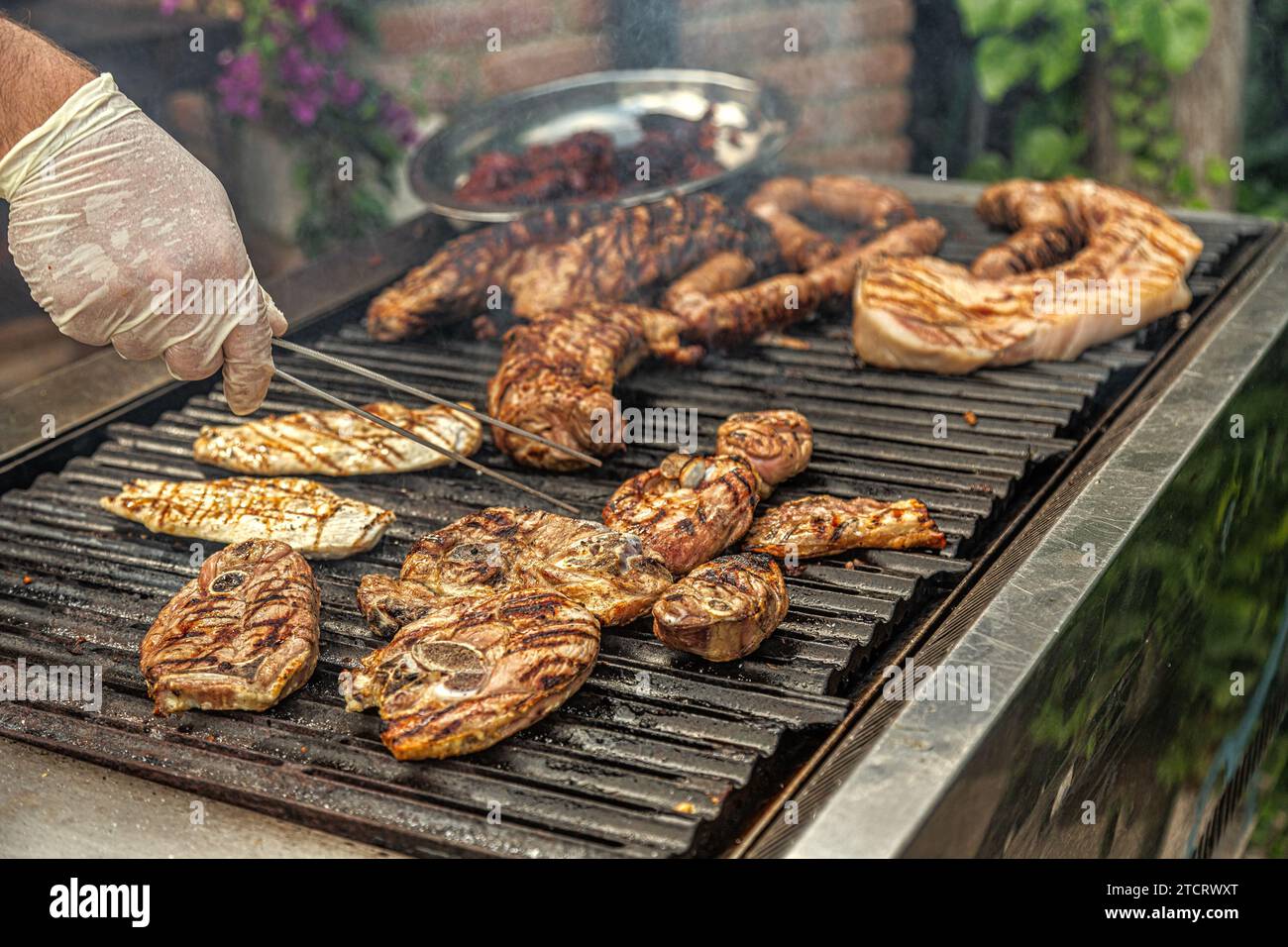 Cucinare carne durante un barbecue. Manzo, pollo, pancia e salsicce. Abruzzo, Italia, Europa Foto Stock