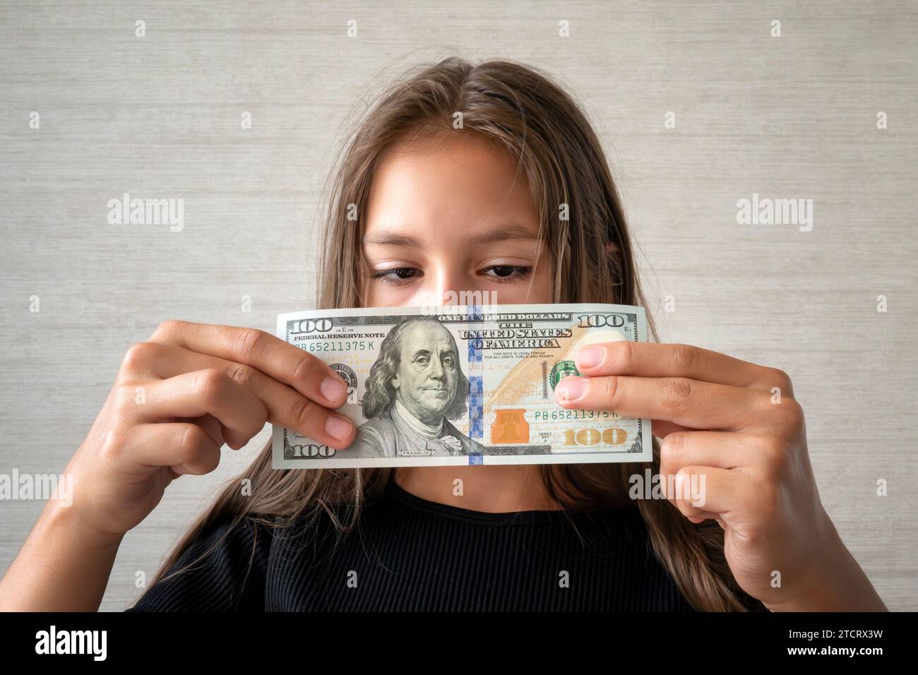 Concetto di soldi, finanze e persone - bambina sorridente con soldi in contanti in dollari. i soldi dei bambini Foto Stock