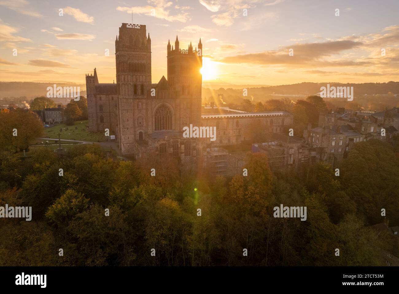 Il sole sorge dietro la cattedrale di Durham, nella contea di Durham, in una splendida mattinata autunnale con il bagliore delle lenti attraverso le torri della cattedrale. Foto Stock