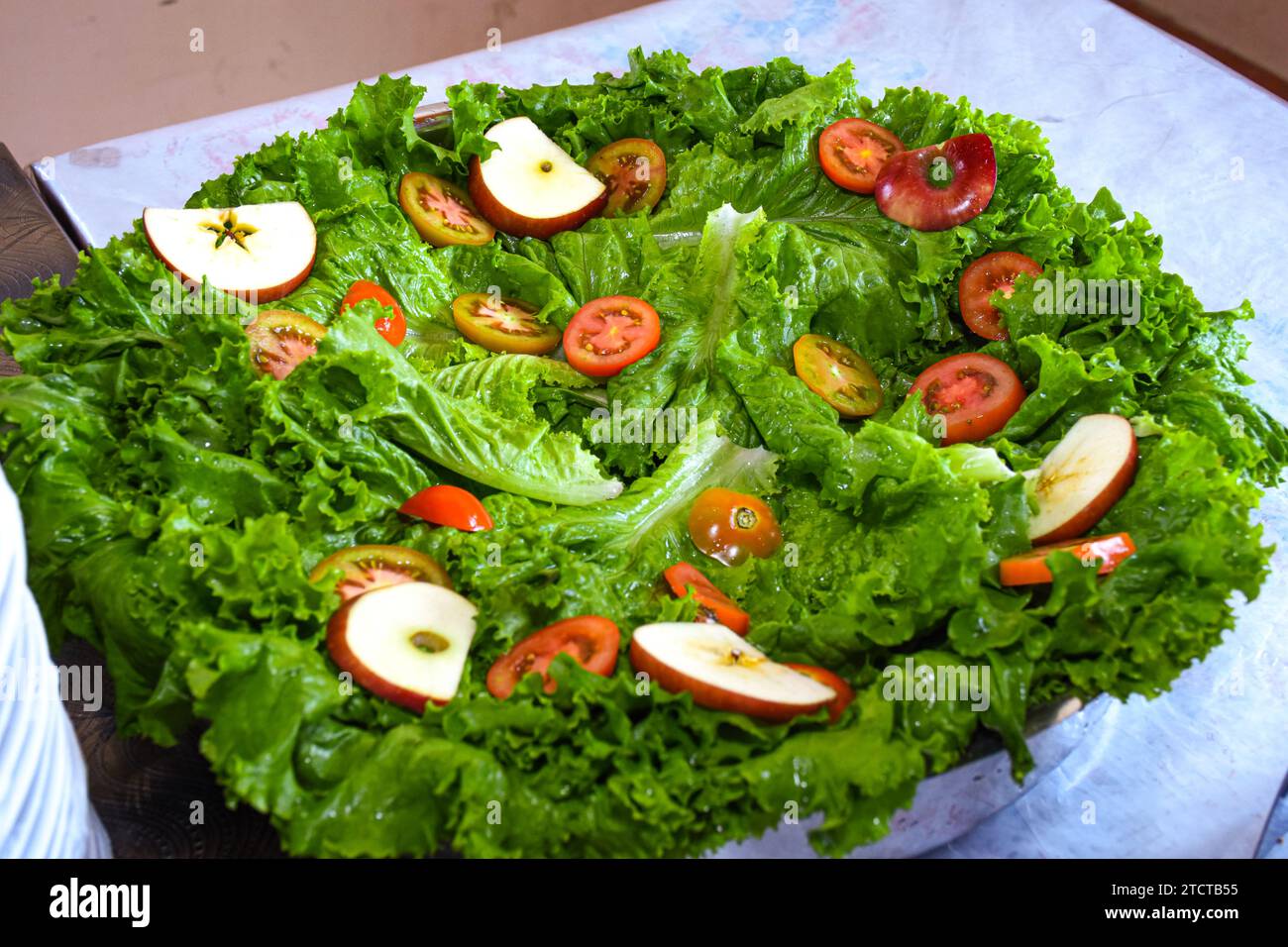 Insalata con aranci, pomodori e mela su un piatto a buffet. Deliziose insalate al tavolo a buffet del ristorante Foto Stock