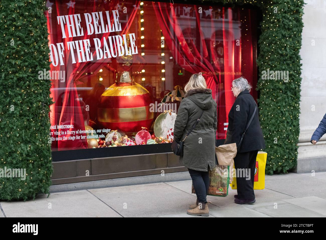 I turisti di Natale si divertono nei grandi magazzini di lusso Selfridges su Oxford Street, vetrina natalizia natalizia, nel centro di Londra, in Inghilterra, nel Regno Unito Foto Stock