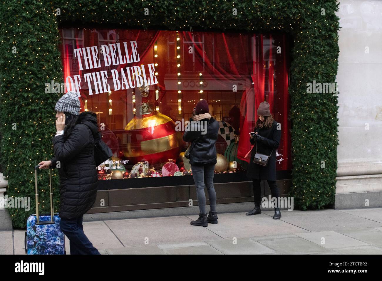 I turisti di Natale si divertono nei grandi magazzini di lusso Selfridges su Oxford Street, vetrina natalizia natalizia, nel centro di Londra, in Inghilterra, nel Regno Unito Foto Stock