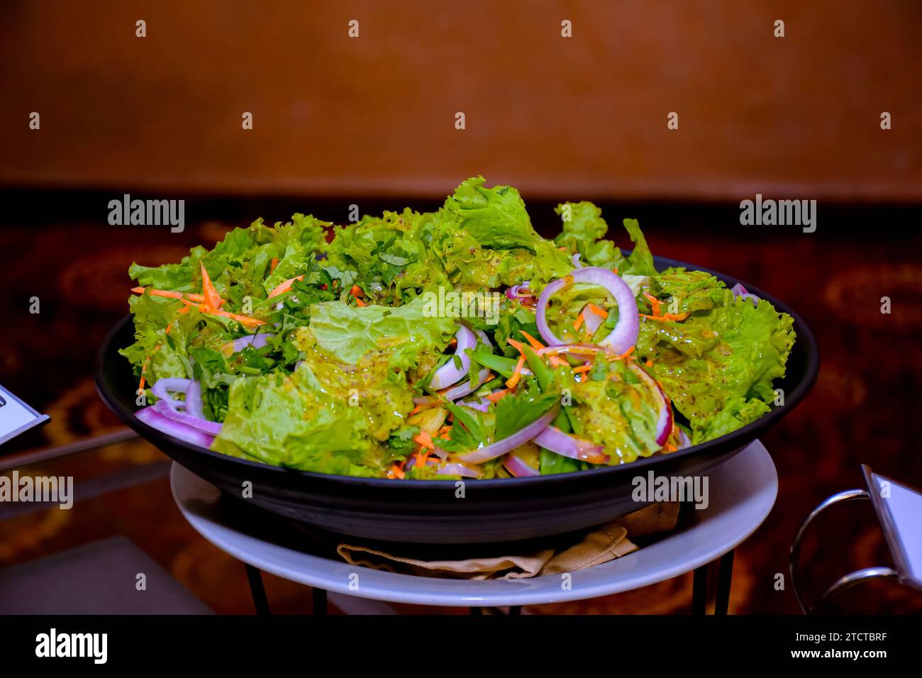 Insalata con aranci, pomodori e mela su un piatto a buffet. Deliziose insalate al tavolo a buffet del ristorante Foto Stock