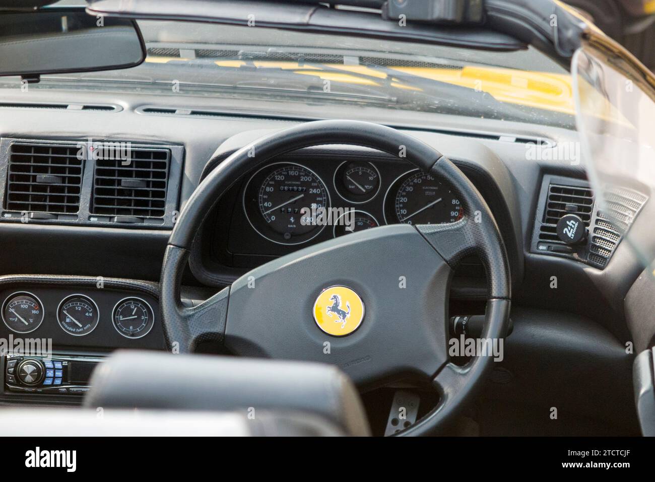 Volante e consolle/cruscotto conducente di un'auto sportiva Ferrari Ferrari con capote aperta d'epoca con guida a destra. (135) Foto Stock