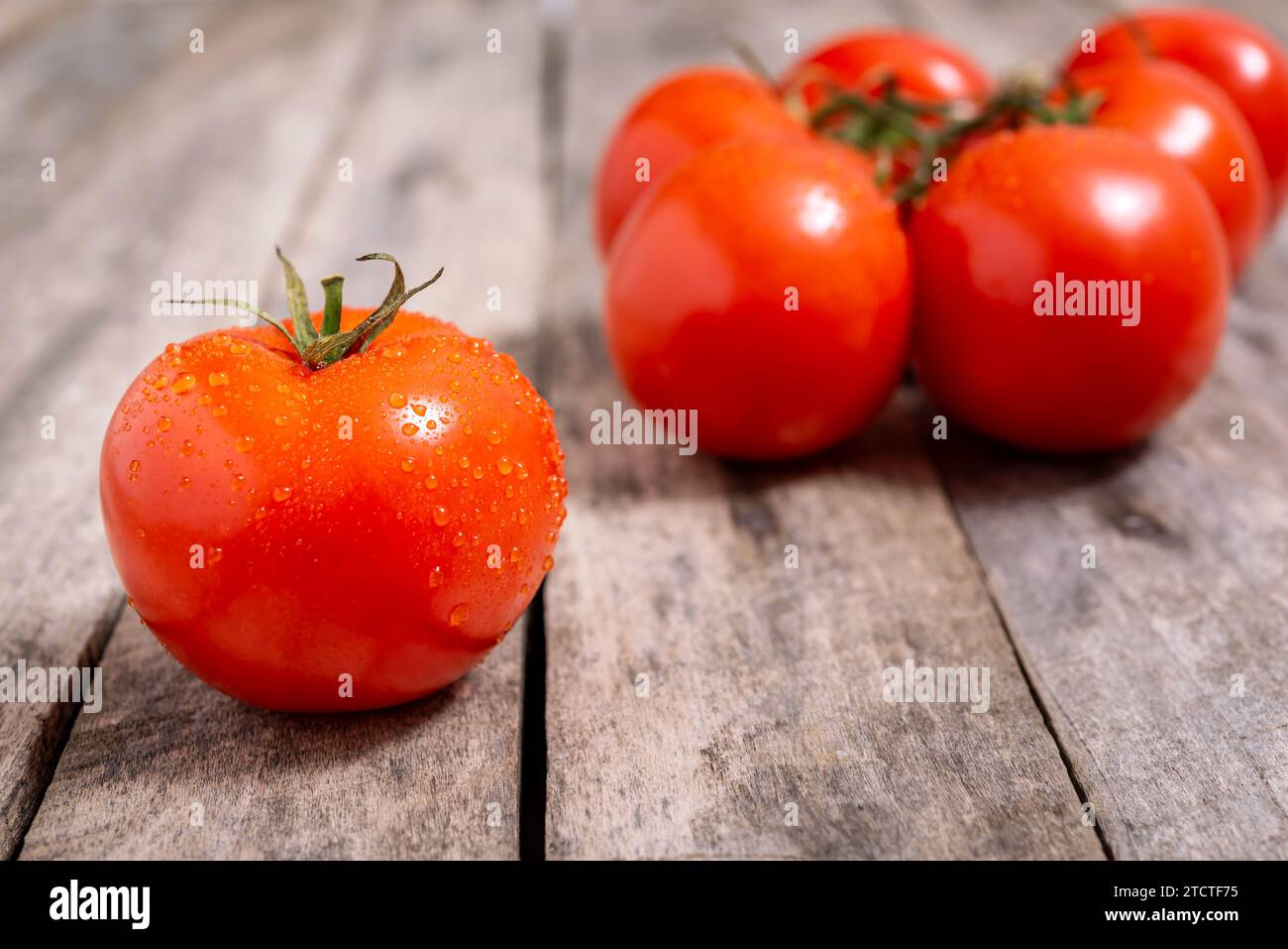 Pomodori rossi maturi su un vecchio tavolo di legno. Messa a fuoco selettiva. Foto Stock