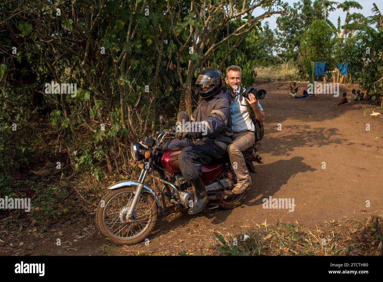 Fotografo che accompagna un funzionario in prestito dell'istituto di microfinanza Encot mentre va a trovare i suoi clienti da un remoto villaggio, regione occidentale, UG Foto Stock