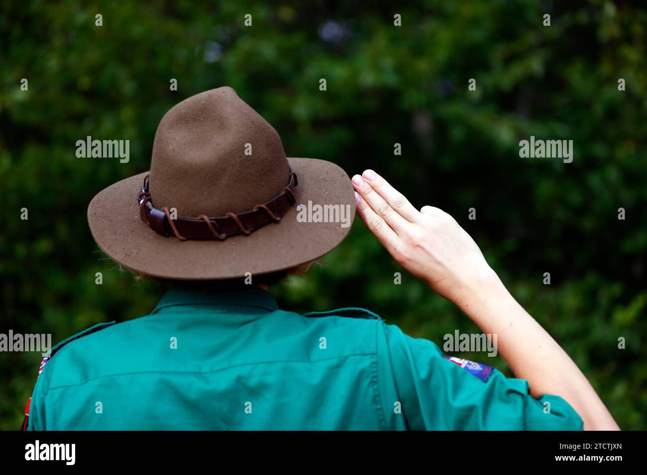 Il boy scout in uniforme esegue un saluto di tre dita. Gesto della mano del simbolo scout. Francia. Foto Stock