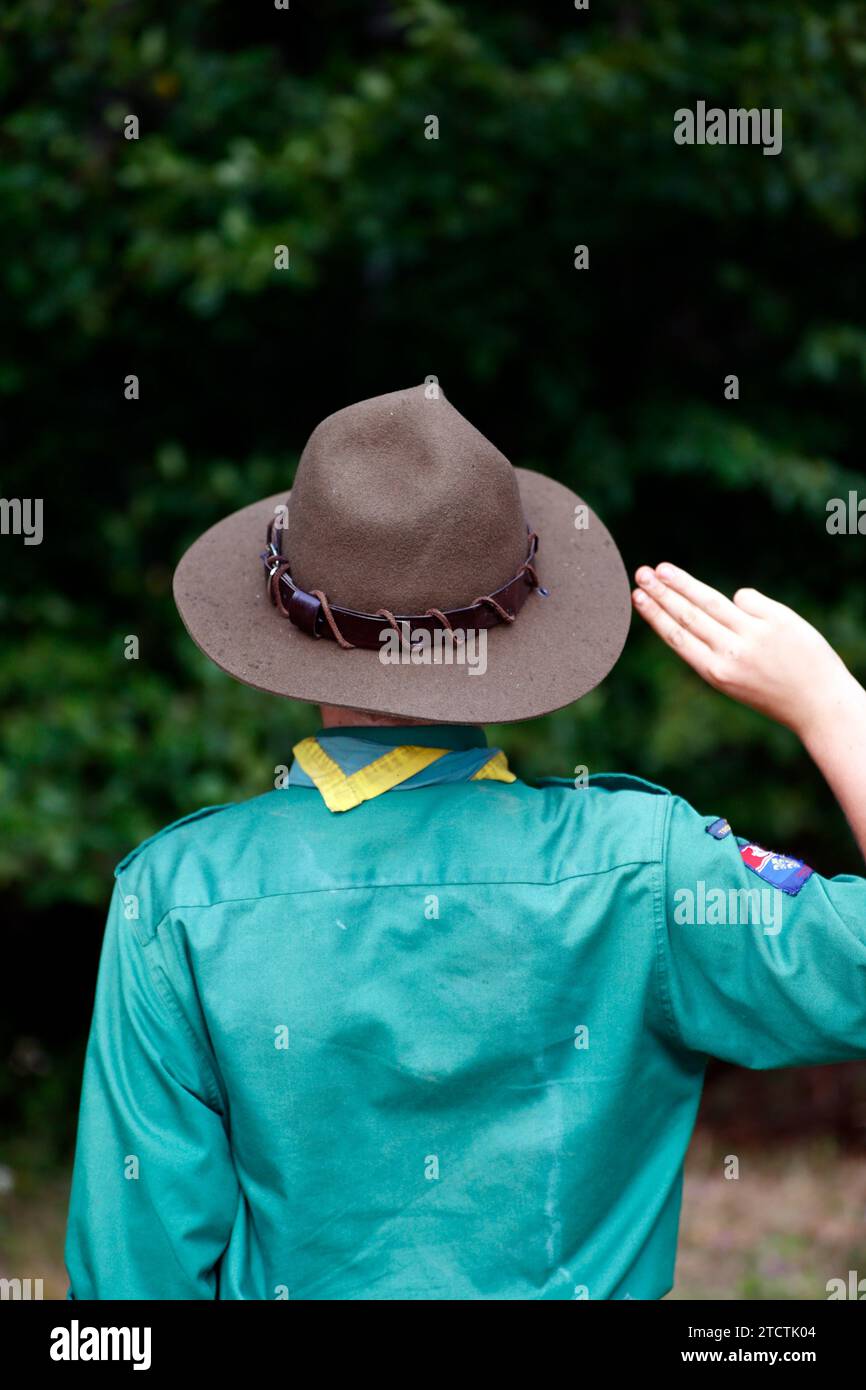 Il boy scout in uniforme esegue un saluto di tre dita. Gesto della mano del simbolo scout. Francia. Foto Stock