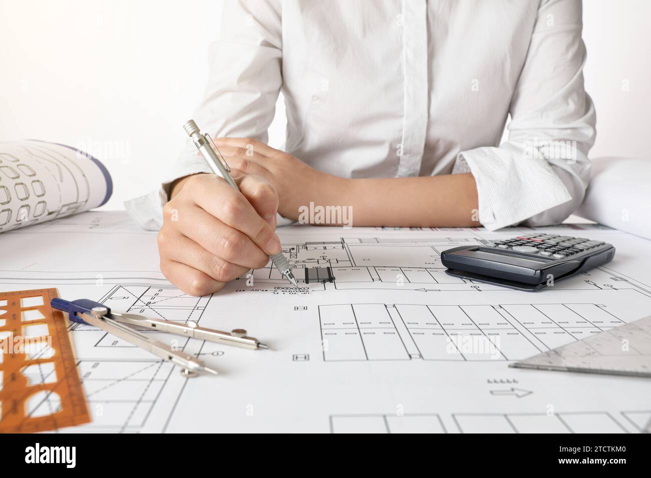 Ingegnere donna che progetta progetti architettonici alla scrivania dell'ufficio Foto Stock