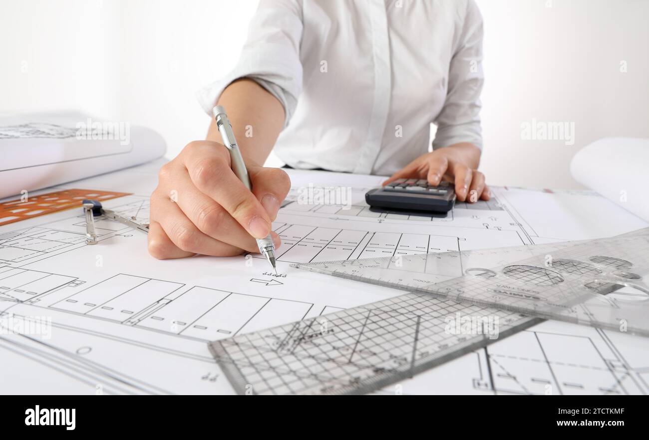 Ingegnere donna che progetta progetti architettonici alla scrivania dell'ufficio Foto Stock