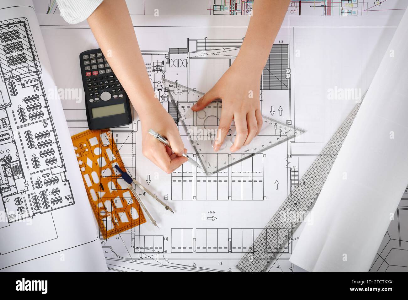 Ingegnere donna che progetta progetti architettonici alla scrivania dell'ufficio Foto Stock