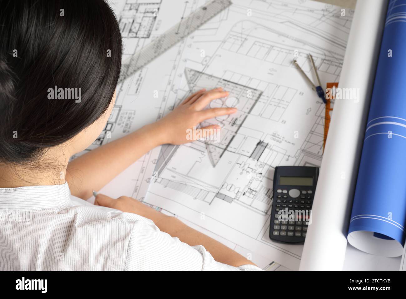 Ingegnere donna che progetta progetti architettonici alla scrivania dell'ufficio Foto Stock