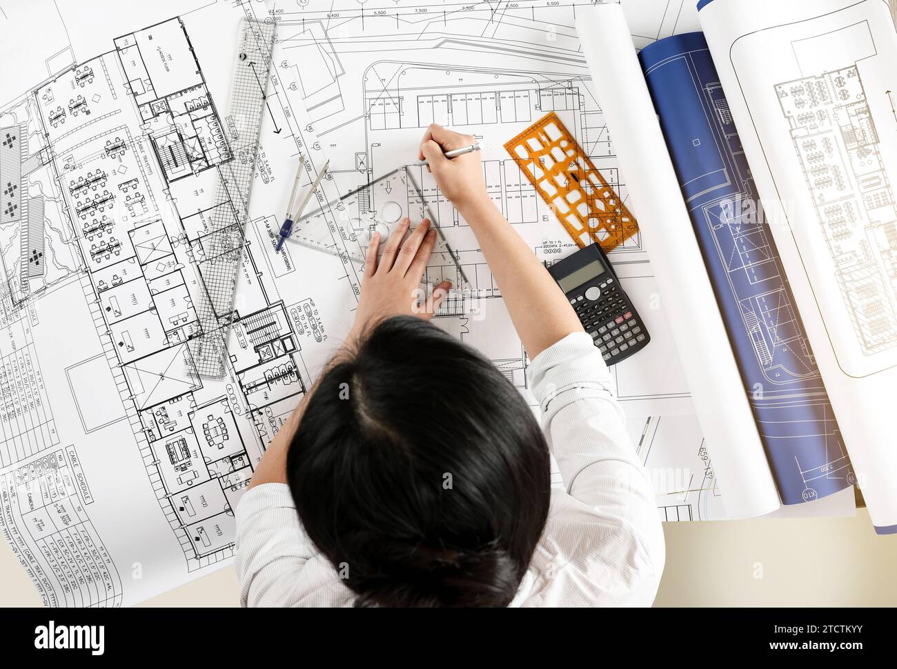 Ingegnere donna che progetta progetti architettonici alla scrivania dell'ufficio Foto Stock