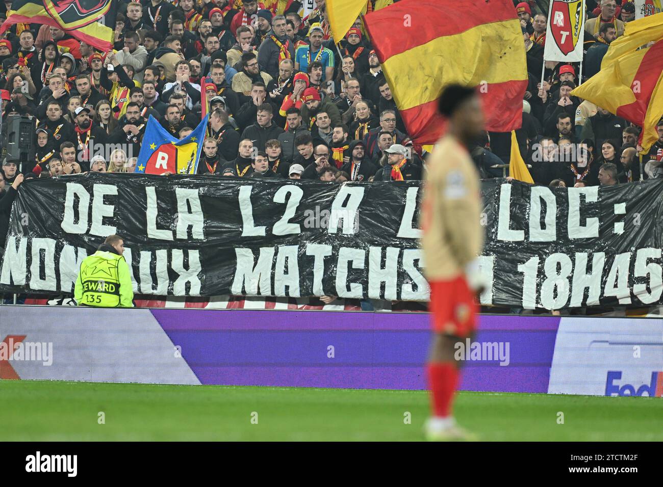 Tifosi e sostenitori di Lens con lo striscione : De la L2 a la LDC : partite non Aux a 18h45 durante la partita di UEFA Champions League 6 nel gruppo B nella stagione 2023-2024 tra Racing Club de Lens e FC Sevilla il 12 dicembre 2023 a Lens, in Francia. (Foto di David Catry / Isosport) Foto Stock
