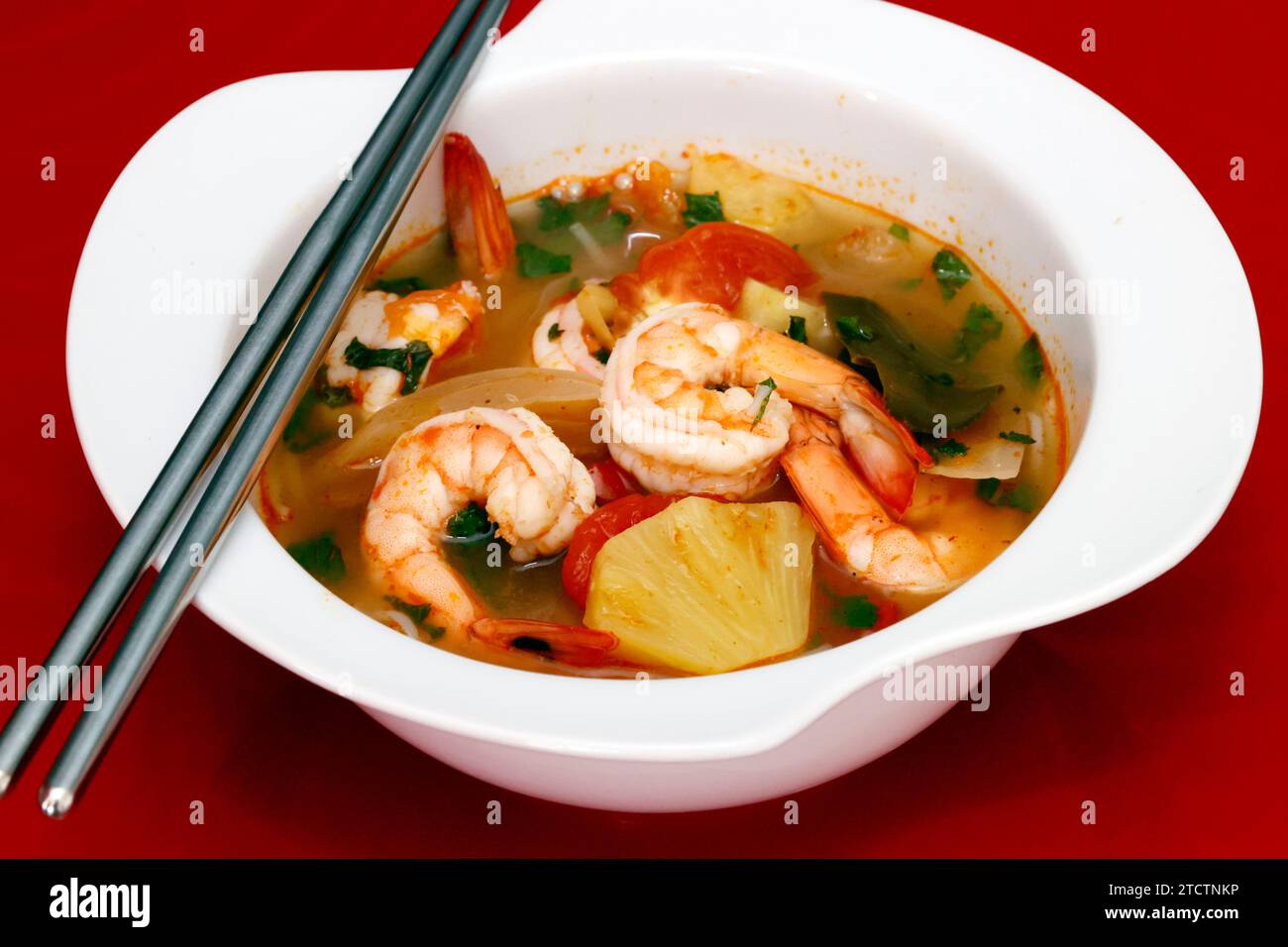 Ciotola di zuppa piccante Thai Tom Yum con gamberi. Foto Stock