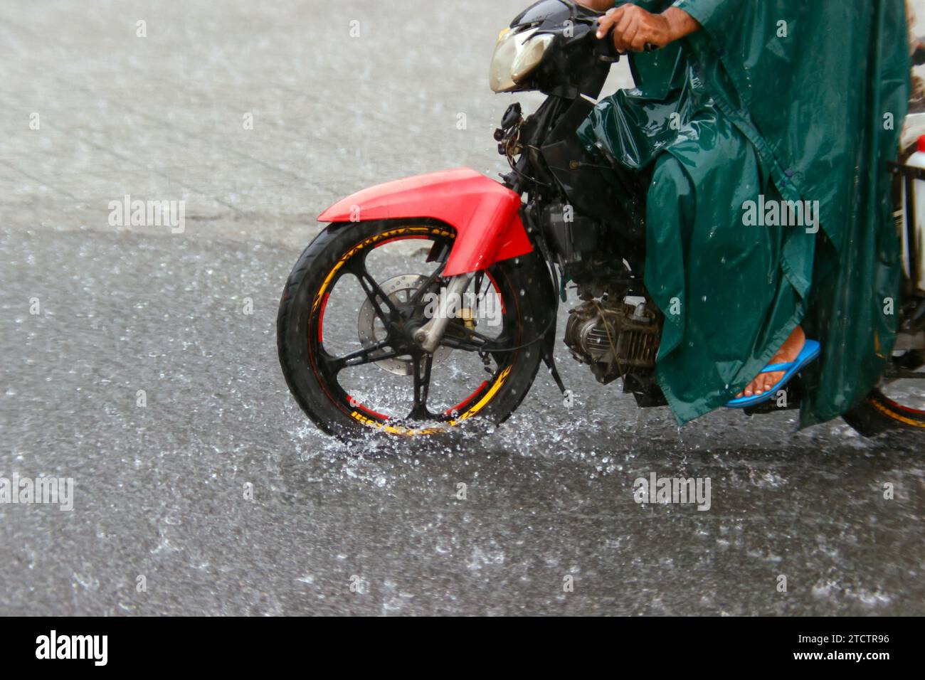 Stagione Monsone. Pioggia intensa e disboscamento dell'acqua su strada. Moto. Foto Stock