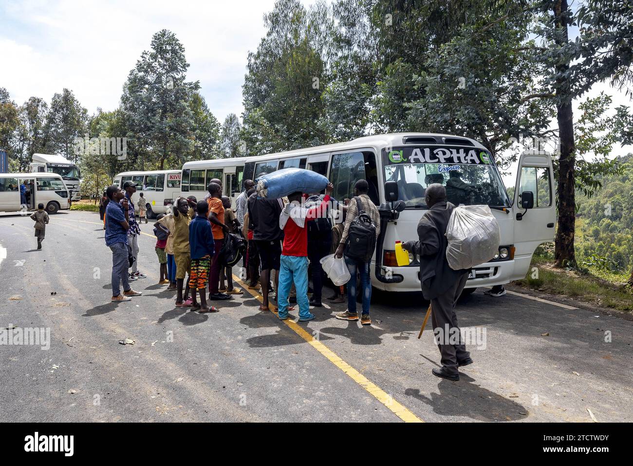 I passeggeri che cambiano autobus dopo un blocco stradale causato da frane nella provincia occidentale del Ruanda Foto Stock
